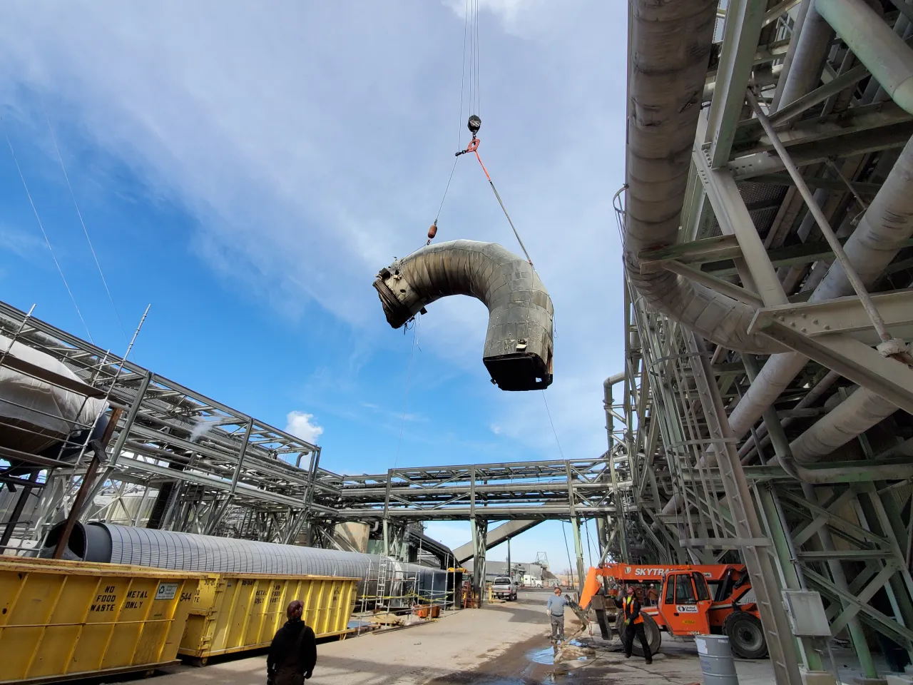 LA Industrial Services crane rigging a large pipe elbow at an industrial facility
